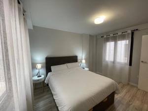 a bedroom with a white bed and a window at Casa Alberto 1 drch in Tudela