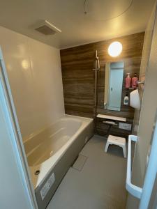 a bathroom with a tub and a sink and a mirror at Sofil 函館First in Hakodate +22 photos