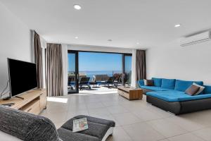 a living room with a blue couch and a television at Ferienhaus Komplex - Villa David - Makarska Exklusiv in Veliko Brdo