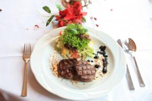 talerz żywności z mięsem i warzywami na stole w obiekcie Hotel & Restaurant Hanse Kogge w Koserowie