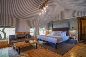 ein großes Schlafzimmer mit einem Bett und einem Sofa in der Unterkunft Everest Base Camp, Near George Everest House, 5kms from Library chowk in Masuri