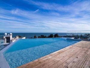 uma piscina com vista para o oceano em Panoramic E Apartment - Rooftop Pool & Sea View & BBQ em Albufeira