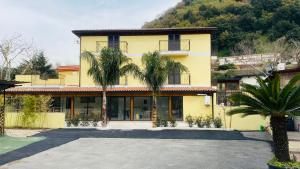 a yellow house with palm trees in front of it at Villa Delle Rose in Naples