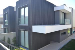 an external view of a black building with a balcony at Süper lüks havuzlu merkezde in Cesme