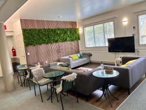 a living room with couches and tables and a tv at ChillOut GuestHouse Lahti in Lahti