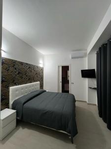 a bedroom with a black bed and a wall at Villa Delle Rose in Naples