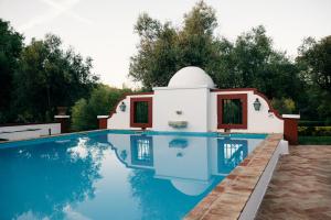 a villa with a swimming pool and a house at Moinho Do Álamo in Montemor-o-Novo