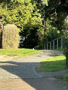 einen Ziegelweg mit einem Zaun und Bäumen in der Unterkunft Haus Seetreppe in Göhren-Lebbin