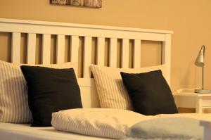 Bett mit schwarzen und weißen Kissen in einem Zimmer in der Unterkunft Landhotel Rehedyk in Sankt Michaelisdonn