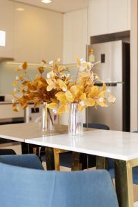 een tafel met twee vazen gevuld met gele bloemen bij Modern Luxury 2 Bedrooms at BTS Nana on 30 Floor in Bangkok