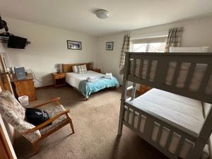 een slaapkamer met een bed en een stapelbed bij Royal Oak Guesthouse in Orkney