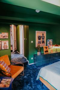 a bedroom with green walls and a bed and a couch at sleepArt green in Celle +8 photos