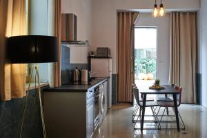 cocina con mesa y cocina pequeña con mesa y sillas en King David Luxury Apartments en Jerusalén