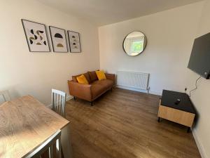 ein Wohnzimmer mit einem Sofa und einem Tisch in der Unterkunft Stunning 4 BED House for Contractors & Holiday Makers in Reading