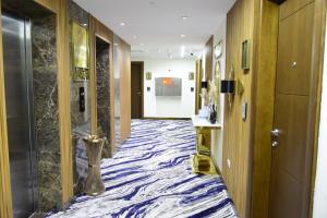 um corredor de um hotel com um tapete azul e branco em Soho Midtown em Ash Shumaysānī