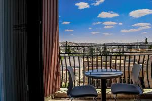 a balcony with a table and chairs and a view at Soho Midtown in Ash Shumaysānī