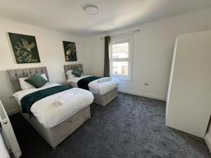 1 Schlafzimmer mit 2 Betten und einem Fenster in der Unterkunft Stunning 4 BED House for Contractors & Holiday Makers in Reading