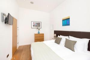 a bedroom with a large bed with white sheets and pillows at JOIVY Superb Flats in the Heart of Edinburgh in Edinburgh