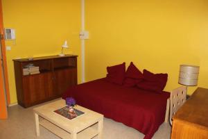 sypialnia z czerwonym łóżkiem i stołem w obiekcie Studio lumineux proche centre-ville de Montpellier w Montpellier
