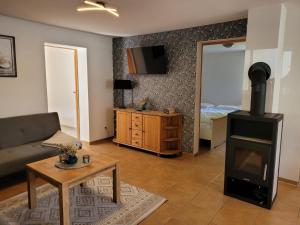 a living room with a wood stove and a bedroom at Ferienwohnung 500m zum See - a55874 in Vollrathsruhe