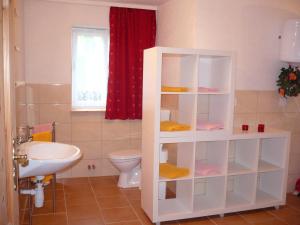 a bathroom with a white shelf next to a toilet at Ferienwohnung 500m zum See - a55874 in Vollrathsruhe