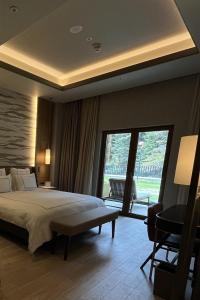 a bedroom with a large bed and a large window at Swissotel Uludag Bursa in Bursa