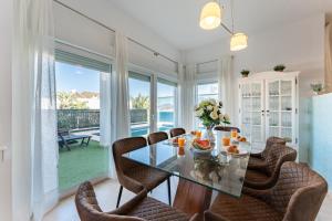 a dining room with a glass table and chairs at CT 297 AL - Faro's Villa Las Arenas - San José in Níjar