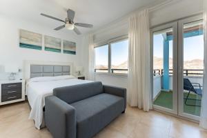 a bedroom with a bed and a couch and windows at CT 297 AL - Faro's Villa Las Arenas - San José in Níjar +47 photos