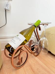 a bottle of wine sitting on a bike with glasses at Eldridge Court Apartment in Dagenham