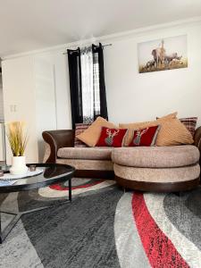 a living room with a couch and a table at Eldridge Court Apartment in Dagenham