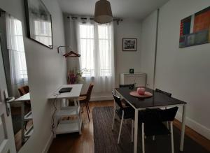 uma cozinha e sala de jantar com mesa e cadeiras em Au Cœur de Troyes - Calme et Confort em Troyes