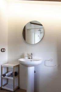 baño con lavabo y espejo en la pared en Masia Villa Pilar Valderrobres en Valderrobres