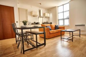 una cucina e un soggiorno con tavolo e sedie di The Tourmaline Suite a Manchester