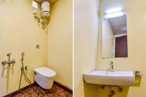 een badkamer met een toilet, een wastafel en een spiegel bij FabHotel Resort Royal Garden Retreat in Mount Ābu