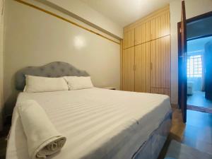 een slaapkamer met een groot wit bed met een blauw hoofdeinde bij Pendeza Hyrax Residence in Nakuru