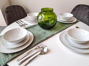 stół z białymi płytami i zielonym wazonem w obiekcie Converted Brewery Apartment w mieście Hull