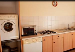 eine Küche mit einem Kochfeld, einem Backofen und einer Mikrowelle in der Unterkunft La boisée de la Conge in Saint-Hilaire-de-Riez