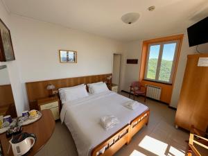 a bedroom with a bed and a table and a window at Hotel Montallegro in Rapallo