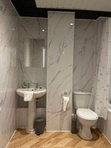 a white bathroom with a sink and a toilet at Eldridge Court Apartment in Dagenham