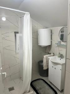 にあるApartmani Doksas Degurićの白いバスルーム(シャワー、シンク付)