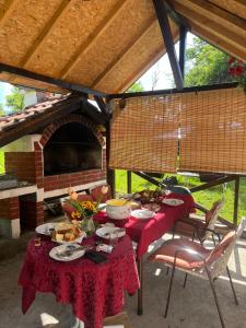 a table with plates of food on top of a patio at Apartmani Doksas Degurić in Belić
