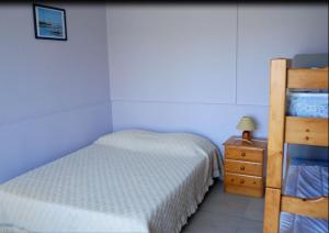 um pequeno quarto com uma cama e uma cómoda em Au Pibolon des bois em Saint-Hilaire-de-Riez