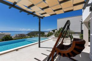 Veliko BrdoにあるFerienhaus Komplex - Villa Amelie - Makarska Exklusivのスイミングプールの隣のパティオにハンモック