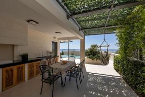 Veliko BrdoにあるFerienhaus Komplex - Villa Amelie - Makarska Exklusivのテーブルと椅子のあるキッチンとダイニングルーム