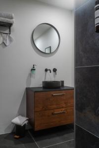 uma casa de banho com um lavatório e um espelho numa cómoda em Bed en Breakfast Hartenlust kamer de Bedstee em Bodegraven