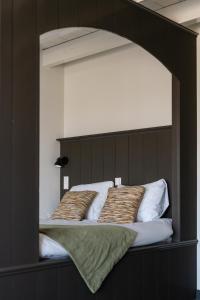 Una cama con dos almohadas encima. en Bed en Breakfast Hartenlust kamer de Bedstee en Bodegraven