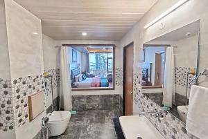 ein Badezimmer mit einer Badewanne, einem Waschbecken und einem Spiegel in der Unterkunft Goroomgo Hotel BD Resort Manali - Excellent Stay with Family, Parking Facilities in Manali