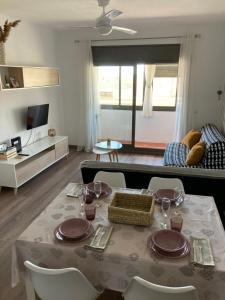 sala de estar con mesa, sillas y sofá en Roshi's Home, en Sant Jaume d'Enveja