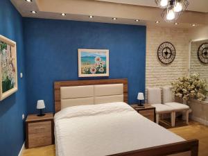 a bedroom with blue walls and a large bed at Central Luxe Apartment in Tirana