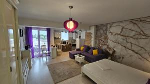 een woonkamer met een paarse bank en een tafel bij Airport Residence 3 in Otopeni